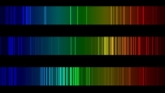 Three spectra stacked vertically. Each spectrum is a rainbow from blue on the left to red on the right, with the brightness varying with color. Each has a different brightness pattern.