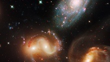 Cropped image of four large galaxies, two interacting with each other.