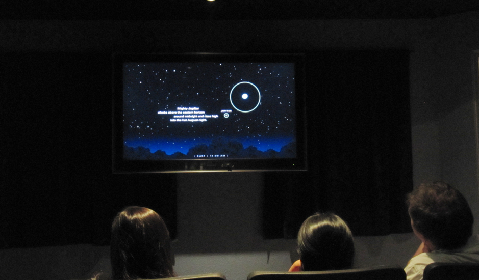 Photograph of a ViewSpace video playing to people in an auditorium.