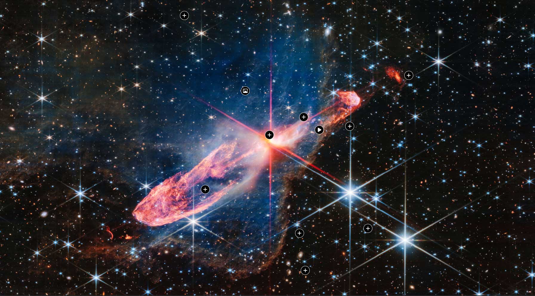 An infrared wavelength view of Herbig-Haro 46/47, which shows two orange lobes, one pointing to the bottom left and the other pointing to the top right with a bright orange star in between the two.