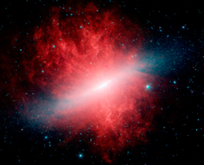 As each slider bar is manipulated, the view transitions from visible light to infrared light. In visible light: In visible light the edge-on disk highlights the geysers of hot gas shooting out of M82's core. In infrared light: Infrared light lets us see this galaxy's full disk of stars and reveals volumes of dust (shown in red) carried along with the hot gas.