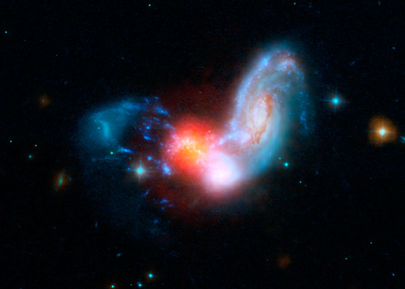 As each slider bar is manipulated, the view transitions from visible light to infrared light. In visible light: The merging galaxies are furiously forming stars inside a dark cocoon of dust. In infrared light: Including infrared light (in red) dramatically reveals where stars are forming.